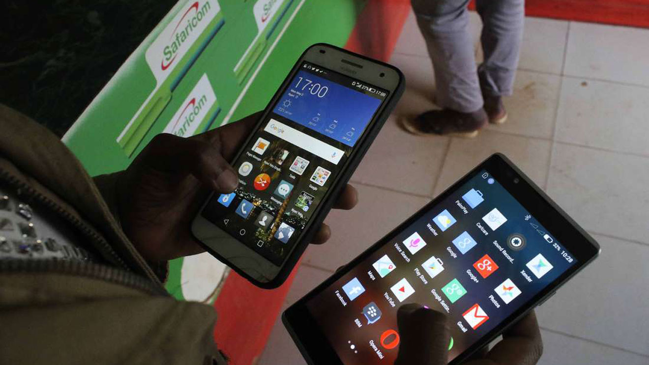 A mobile subscriber uses two smart phones to share information. FILE PHOTO