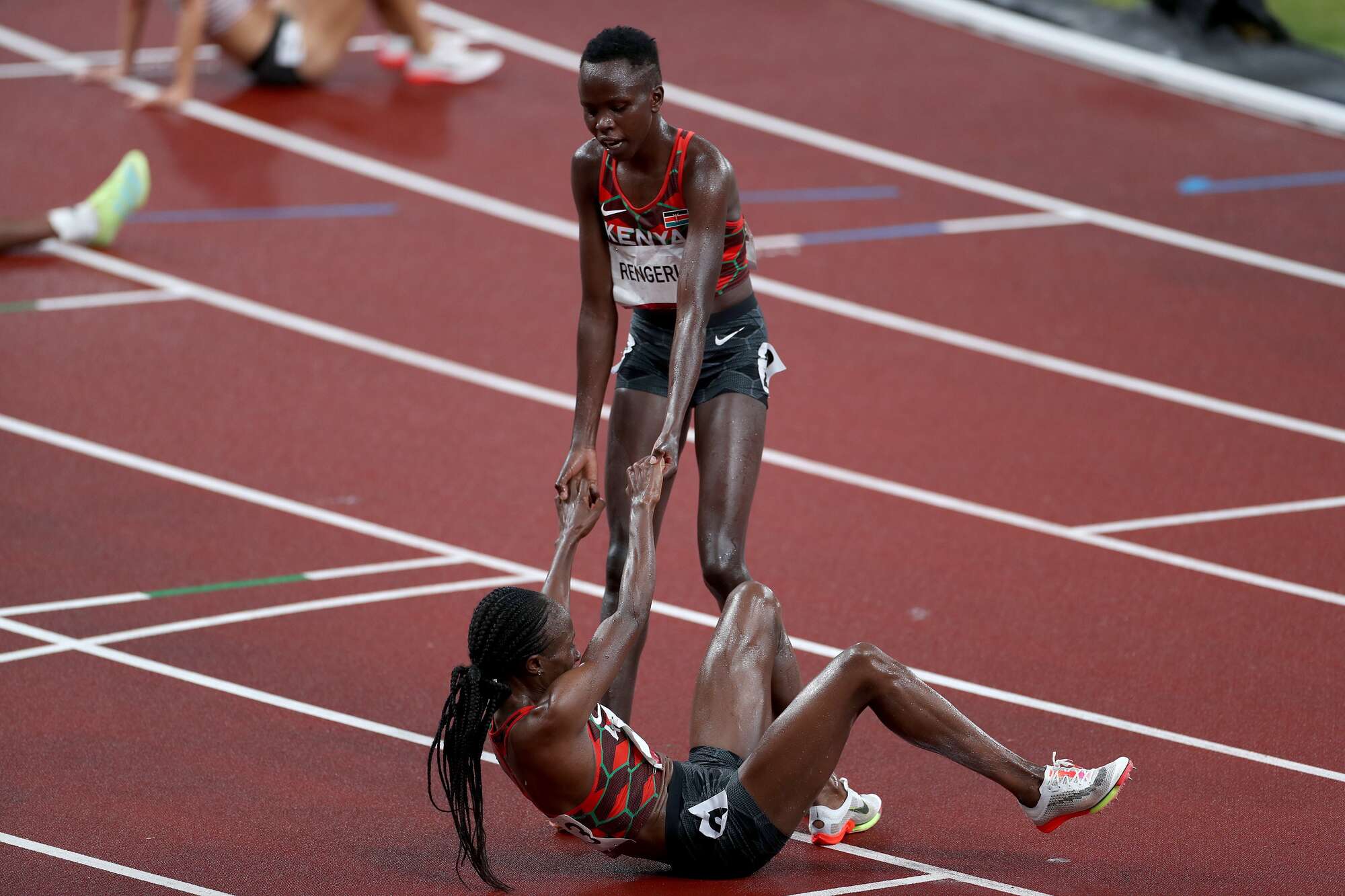  Kenya's Lilian Kasait Rengeruk (right) helps up Hellen Obiri after the women's 5000m final during the Tokyo 2020 Olympic Games